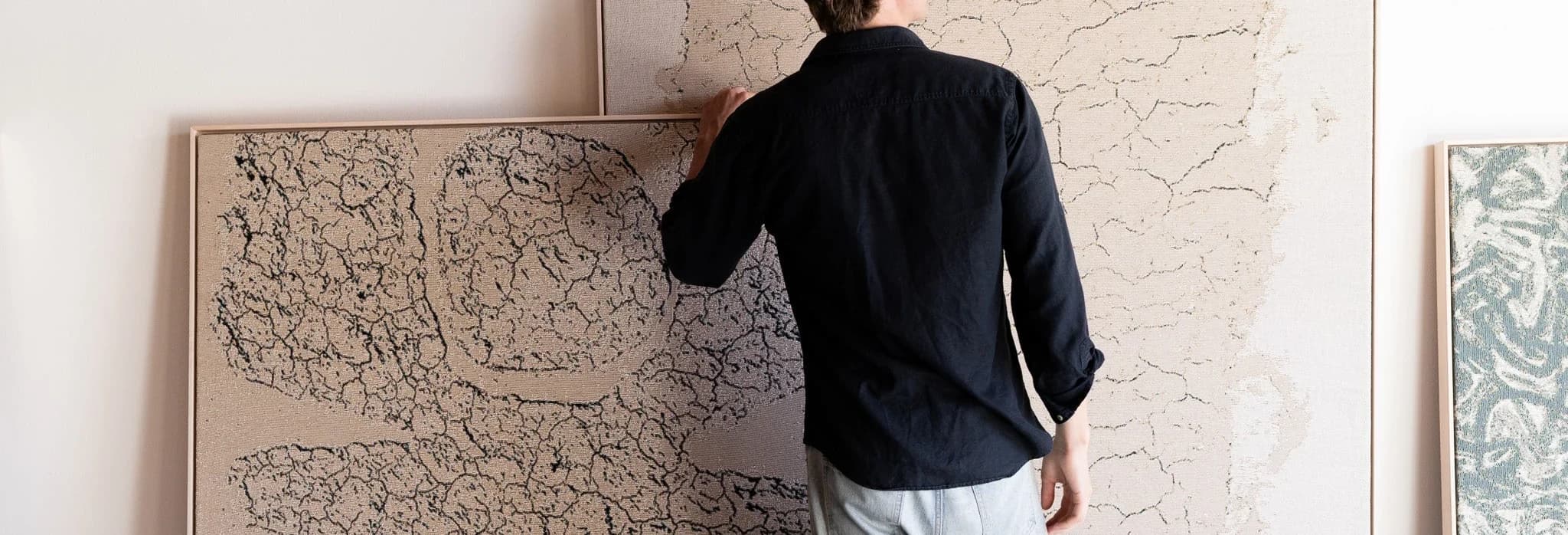 An interior with framed line-work panels being positioned against a pale wall