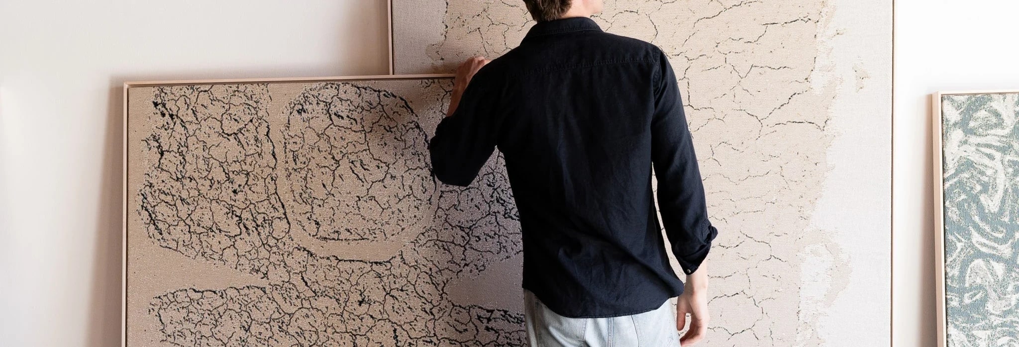 An interior with framed line-work panels being positioned against a pale wall