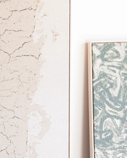 A textured plaster wall beside a framed panel with marbled surface detail