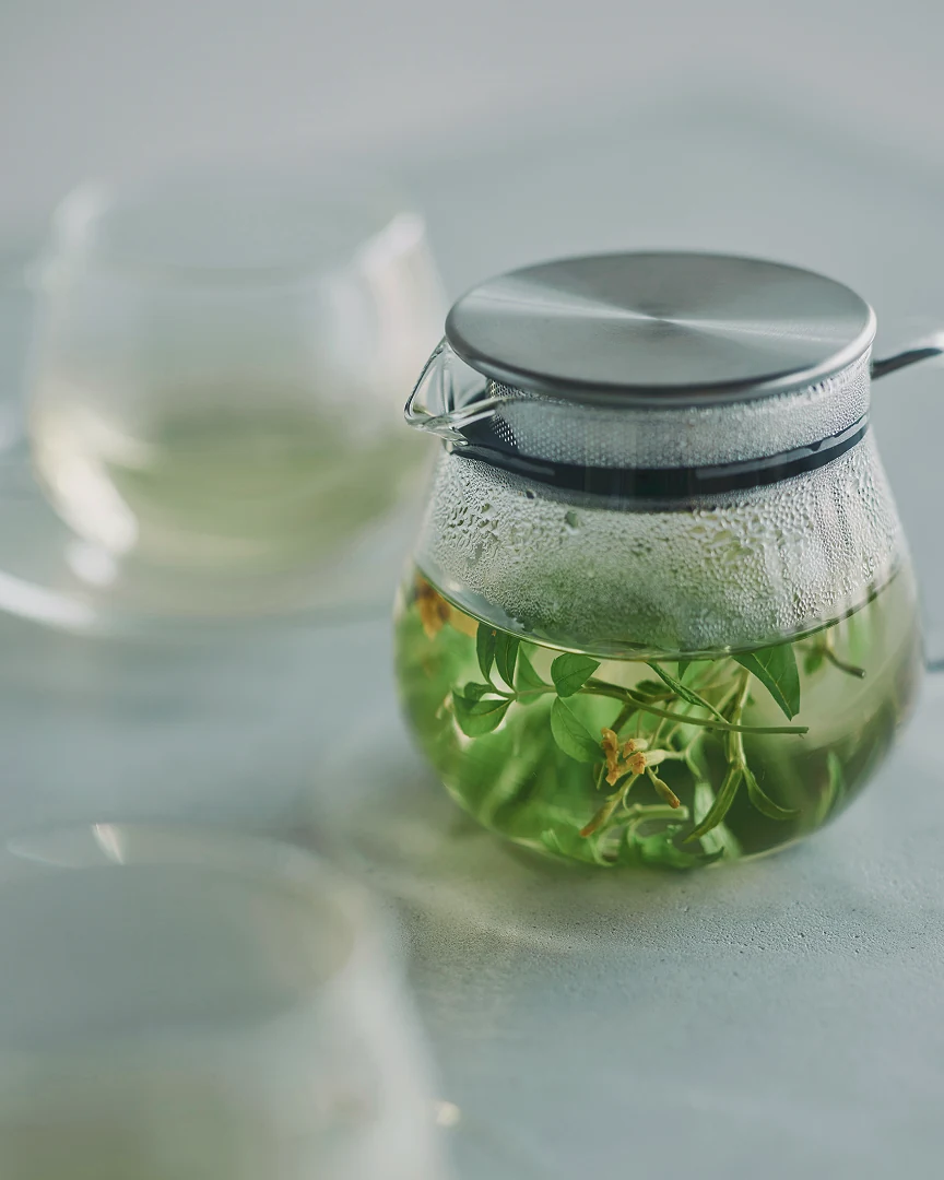 A glass teapot with a steel lid, infusing loose leaf